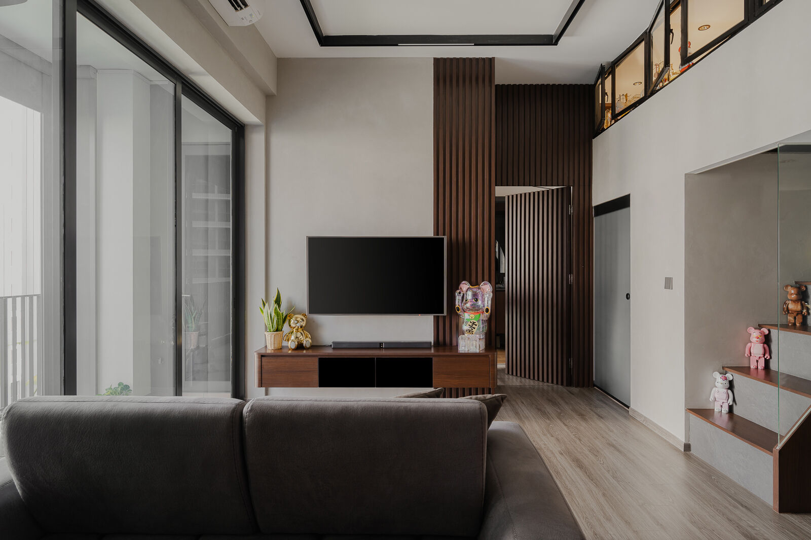 Dark timber slats run the full double-height wall, holding the room together across two storeys. — Boathouse Residence, Upper Serangoon